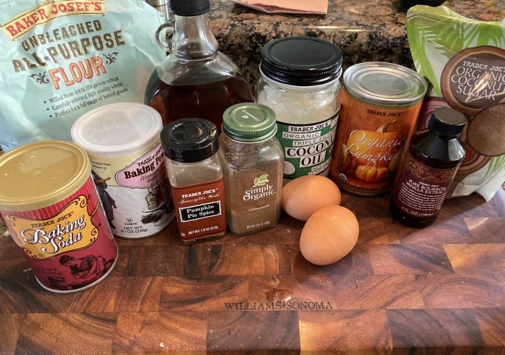 individual ingredients for pumpkin bread on a wooden cutting board