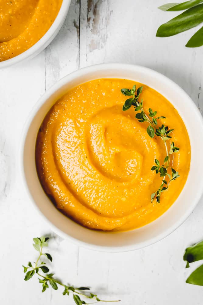 a bowl of butternut squash soup with fresh herbs