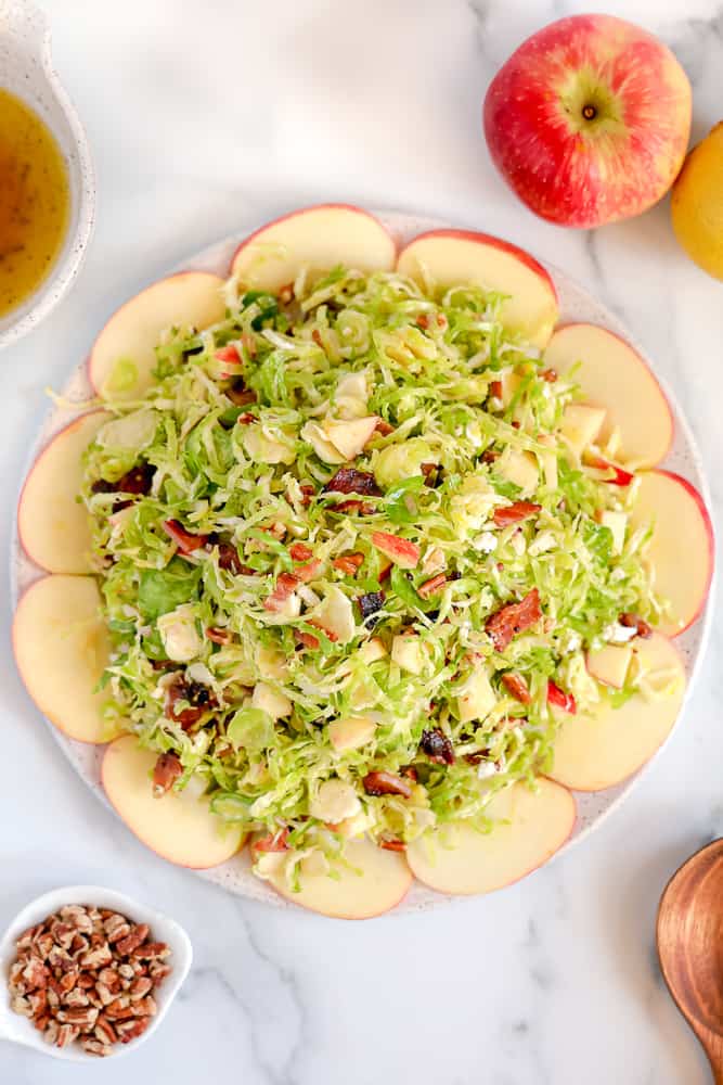 overhead photo of shaved brussels sprouts surrounded by sliced apples