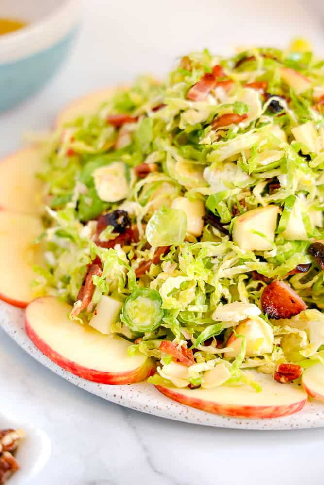 close up shaved brussels sprouts salad with bacon, goat cheese, and pecans