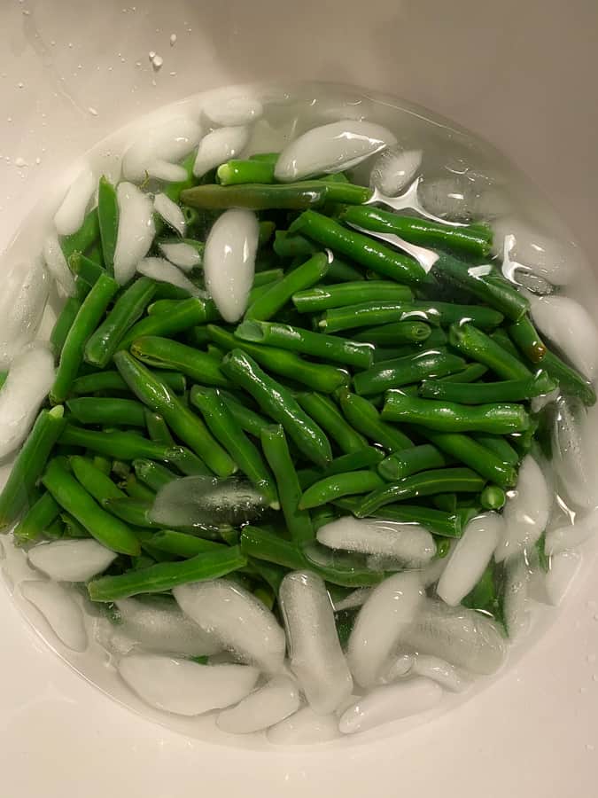 green beans in a bowl in an ice bath