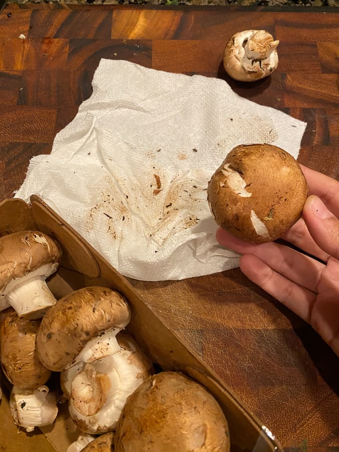 mushrooms on a cutting board with a paper towel 