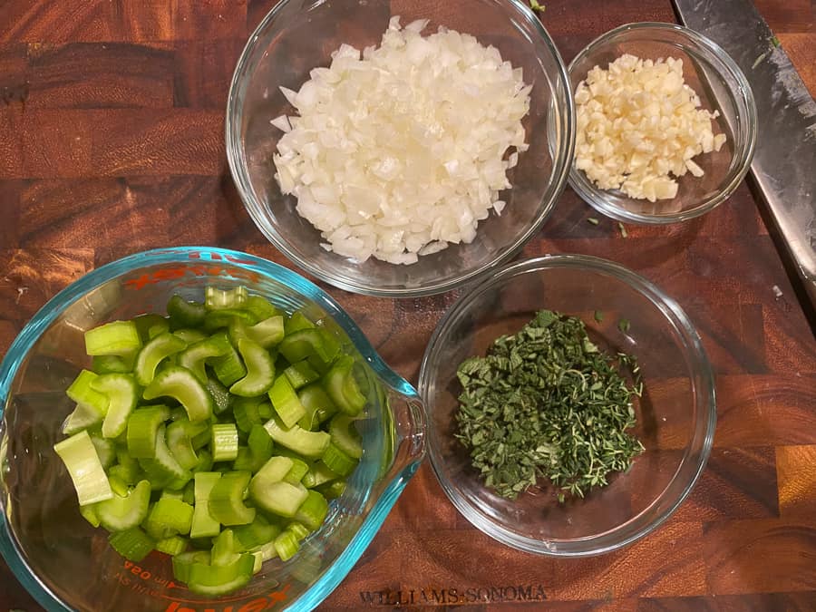 bowls of chopped celery, onion, garlic, and fresh herbs