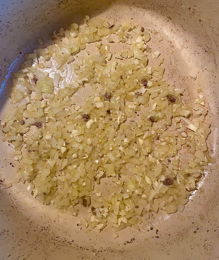 minced garlic and diced onion sautéing in a dutch oven