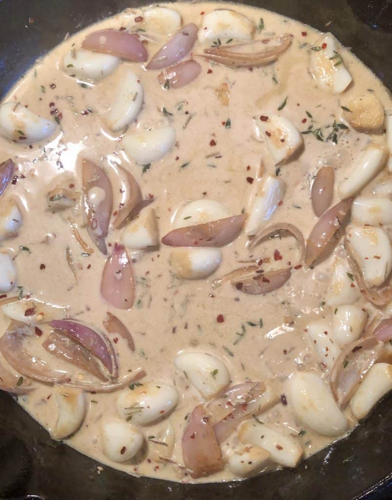 white wine cream sauce with whole garlic cloves and shallots with fresh thyme