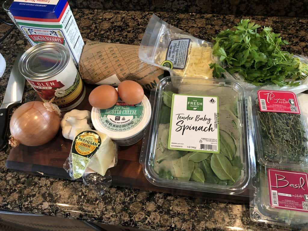 spinach and beef lasagna ingredients laid out on a cutting board