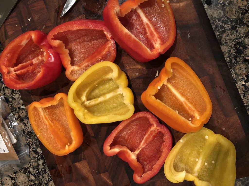 hollowed out bell peppers on top of wooden cutting board
