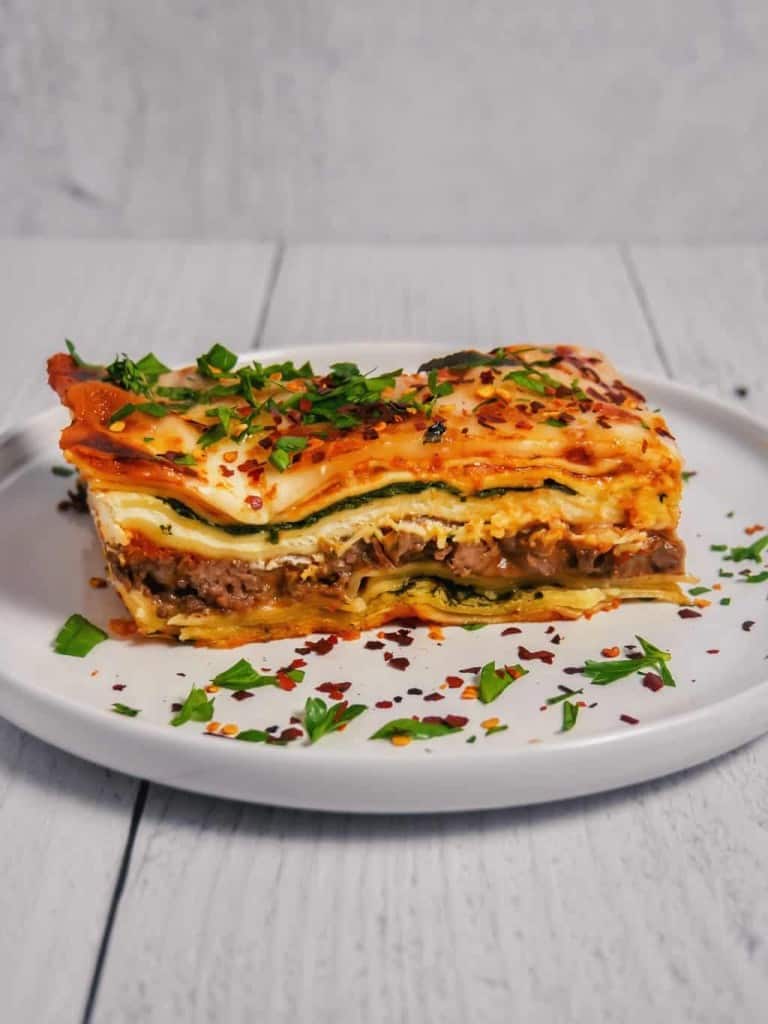 layers of spinach and beef lasagna with cheese and bechamel sauce