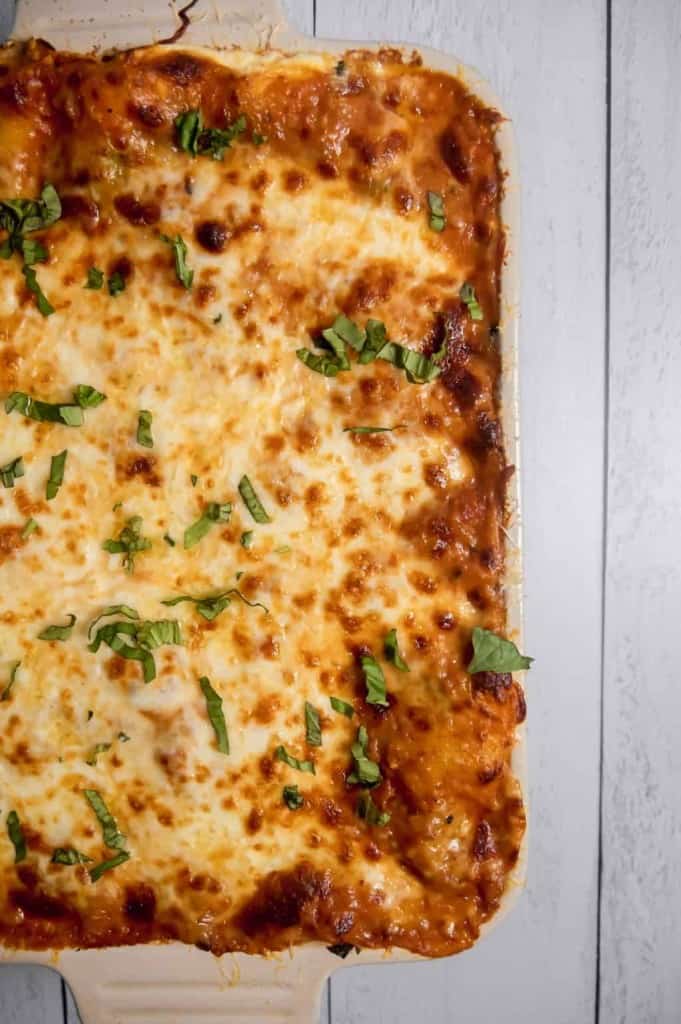 Overhead shot of spinach and beef lasagna in baking dish with brown bubbly cheese
