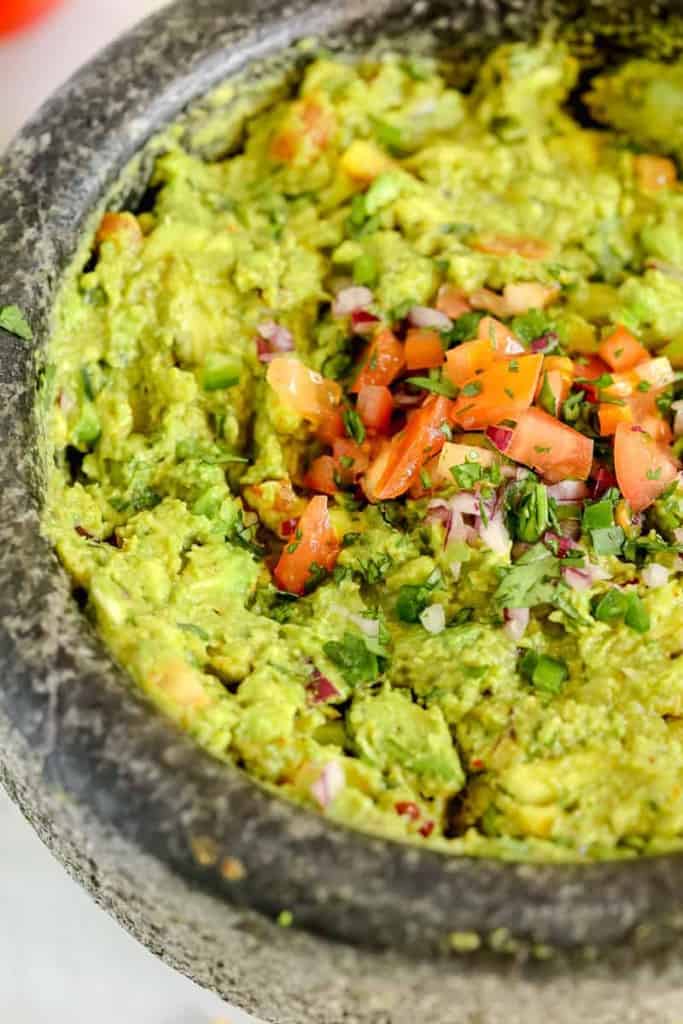 close up of homemade guacamole in a molcajete