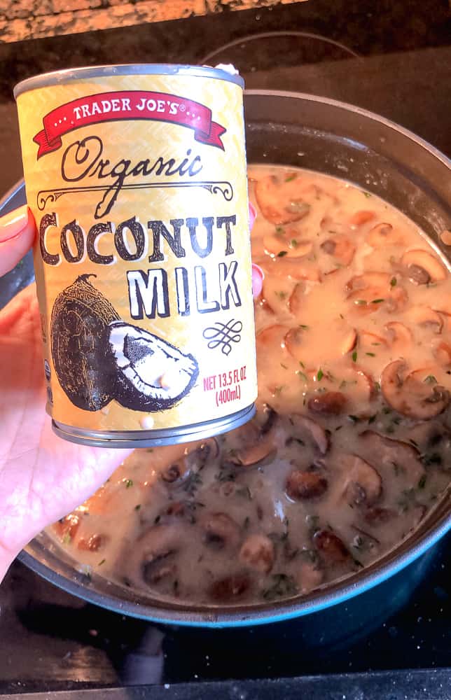photo of can of coconut milk with soup cooking in the background