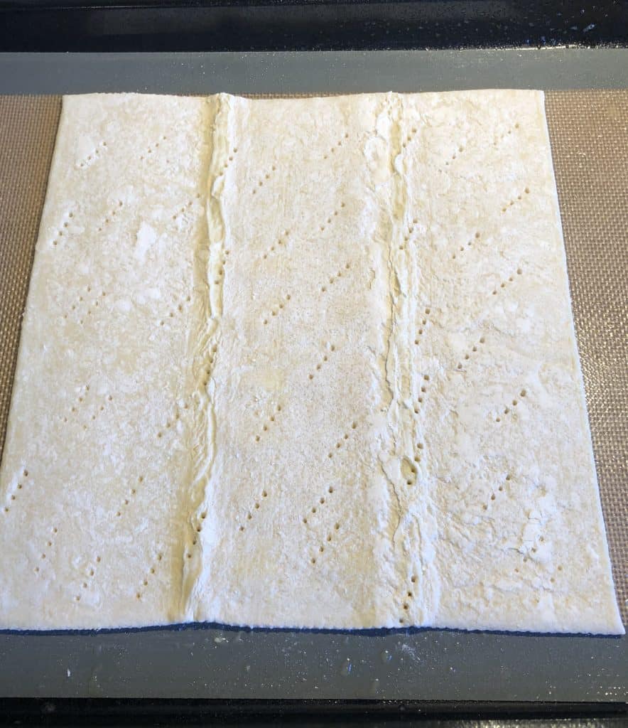 puff pastry on a baking sheet with holes poked all over