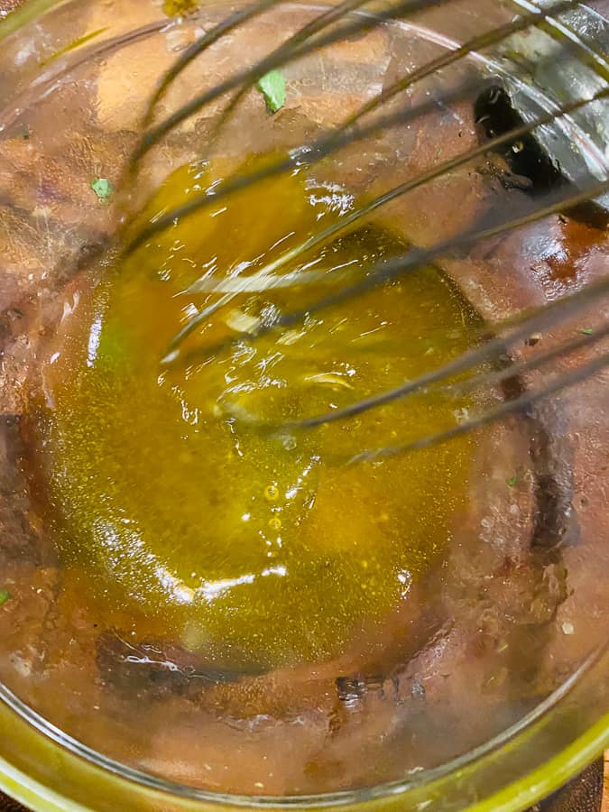 honey and olive oil being whisked in a bowl