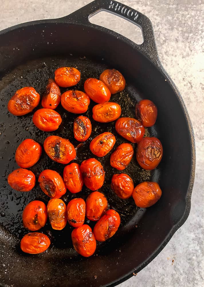 cast iron skillet with blistered tomato inside