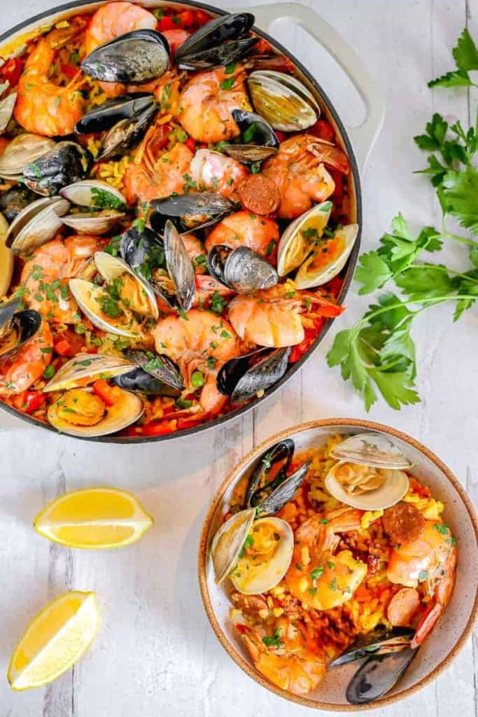 skillet of seafood paella with a smaller bowl 