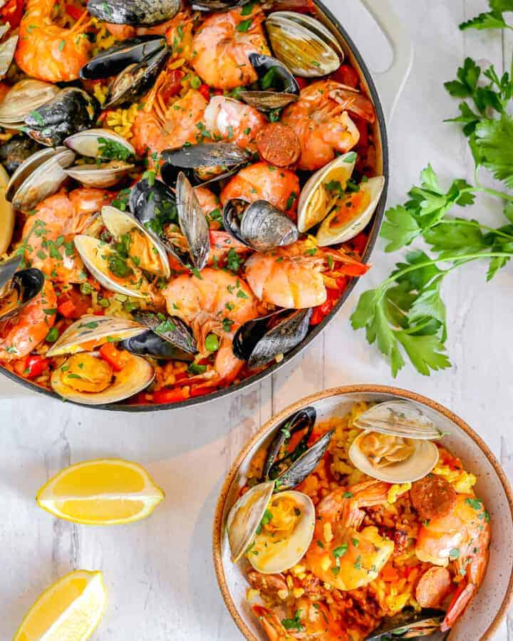 skillet of seafood paella with a smaller bowl