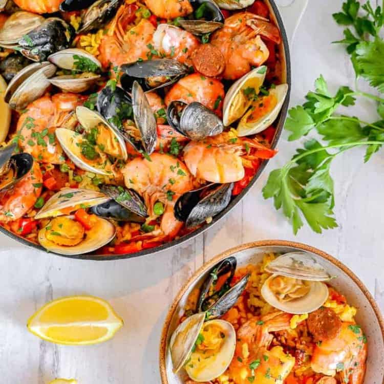 skillet of seafood paella with a smaller bowl