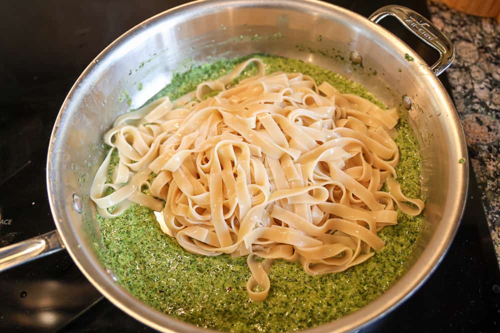 pasta noodles put in pesto sauce