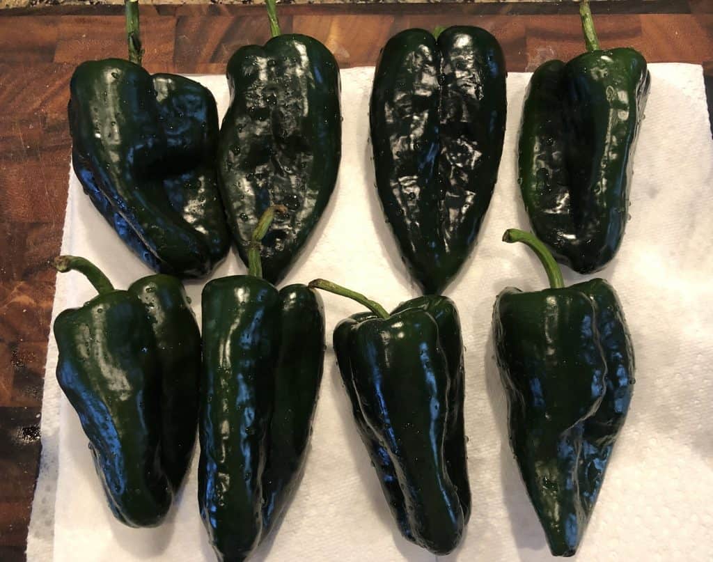 whole poblano peppers on a cutting board