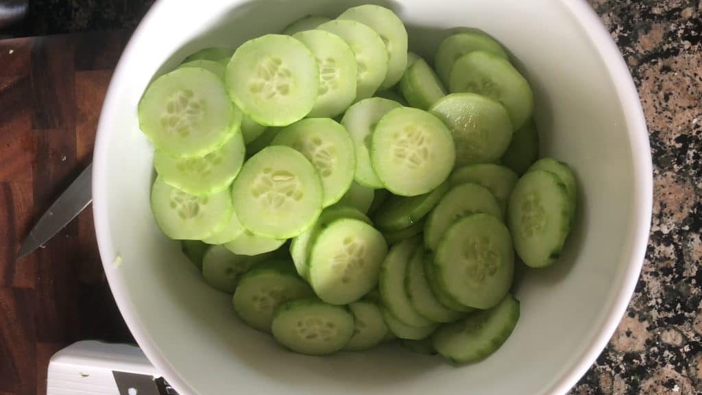 sliced cucumbers in a white bowl
