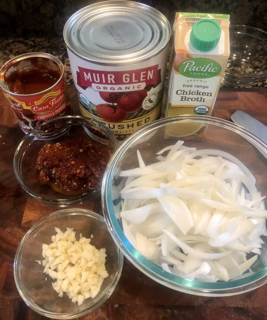 ingredients for chicken tinga on a cutting board