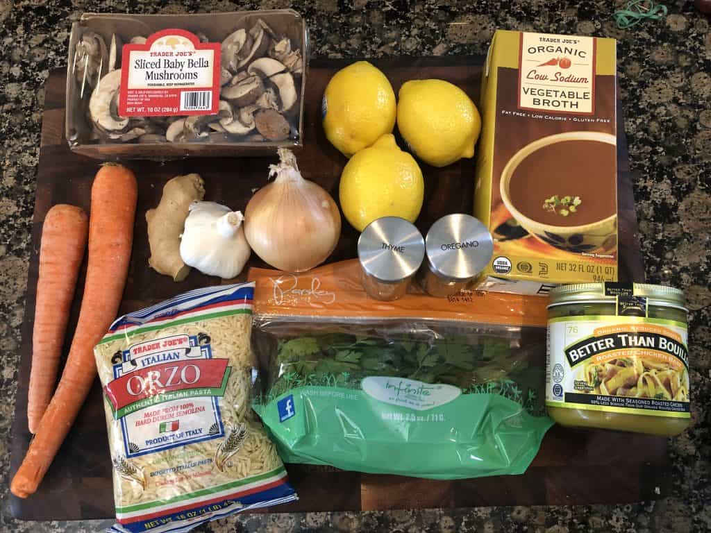 vegetable orzo soup ingredients laying out on a cutting board