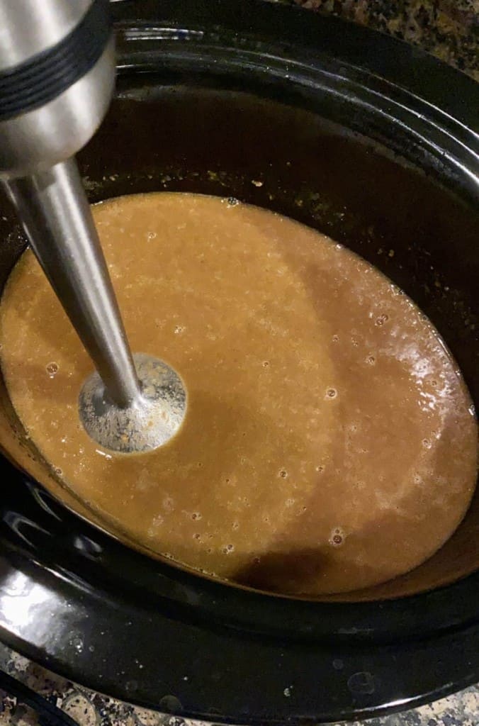 immersion blender in the crockpot making gravy