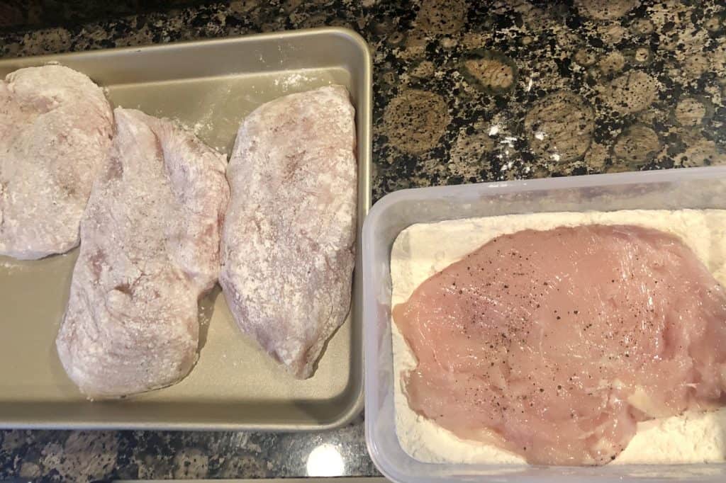 four chicken breasts coated in all purpose flour