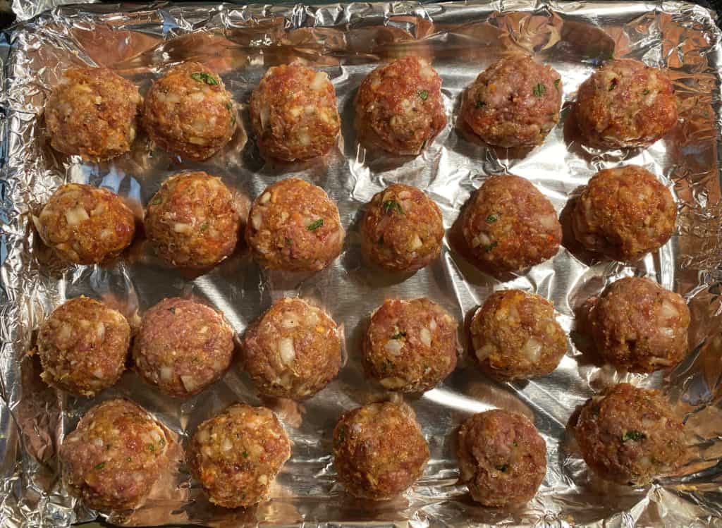 formed meatballs on a baking sheet on foil pre cook