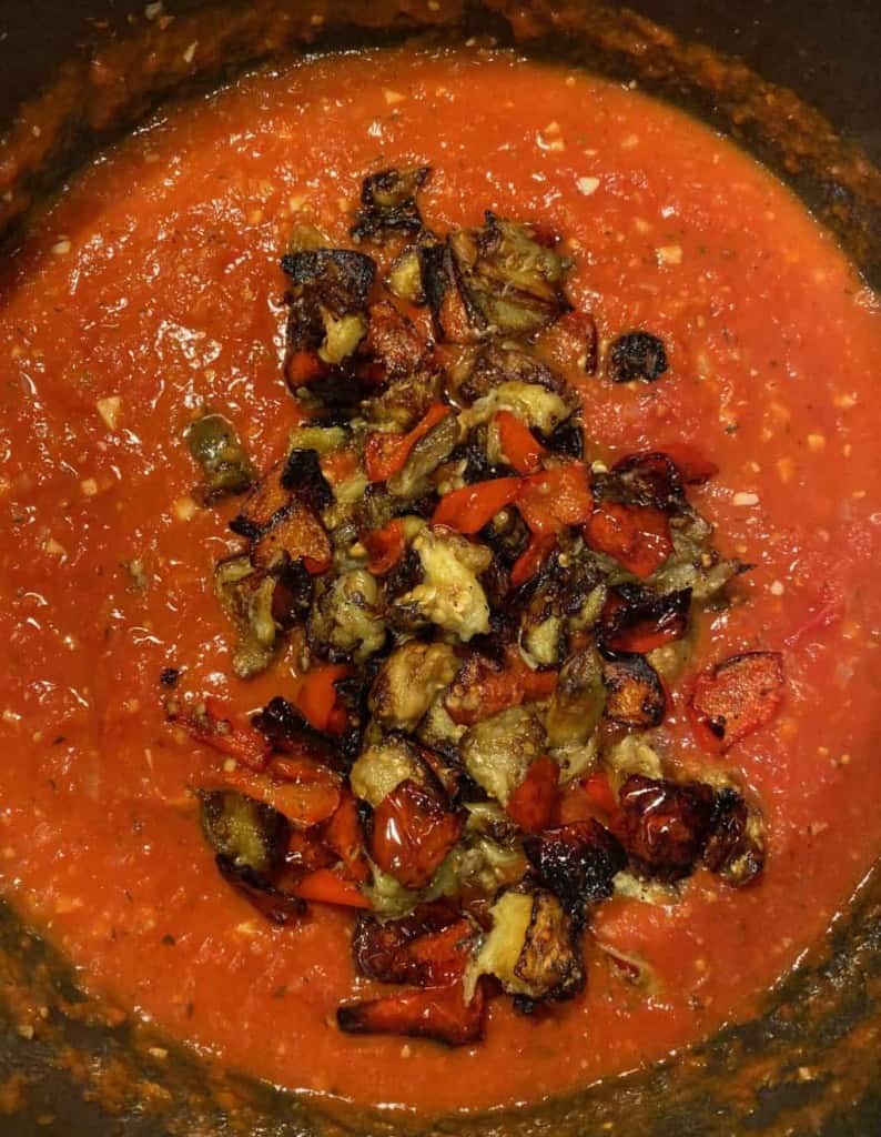 overhead shot of red sauce with roasted eggplant and bell peppers inside
