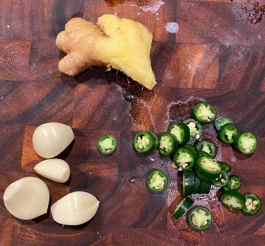 ginger, garlic, and serrano peppers on a cutting board