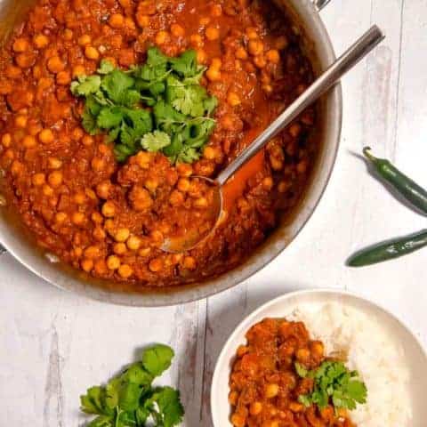 Overhead photo of a skillet with chickpea masala and a bowl of rice