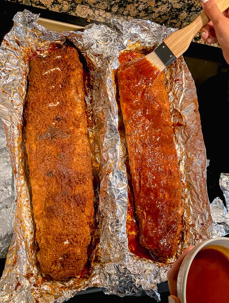 photo of brushing BBQ sauce on oven baked dry rub ribs