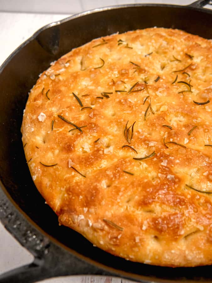 close up shot of cast iron focaccia bread with rosemary 