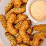 close up shot of panko breaded avocado fries on a plate with dipping sauce