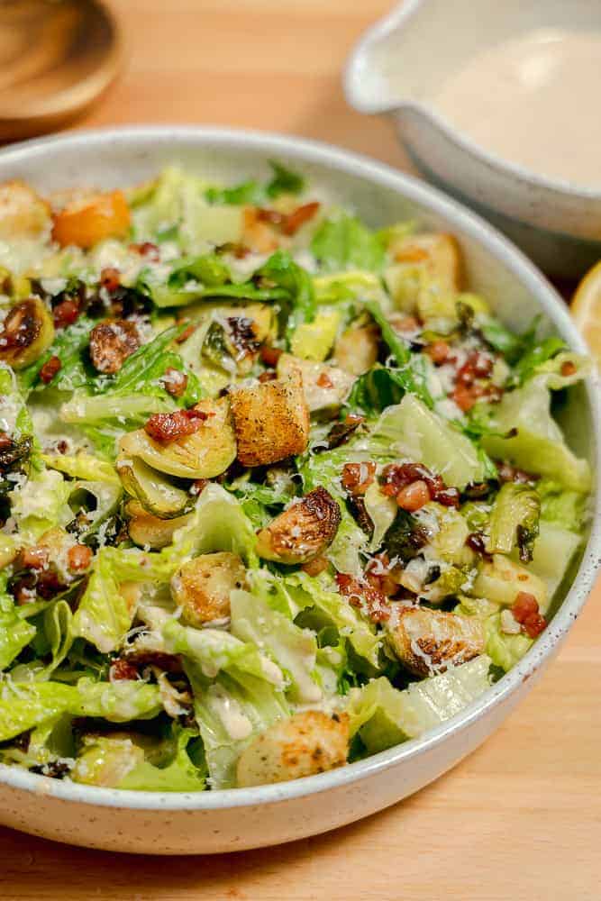 bowl with brussels sprouts, lettuce, pancetta, and croutons, with caesar dressing
