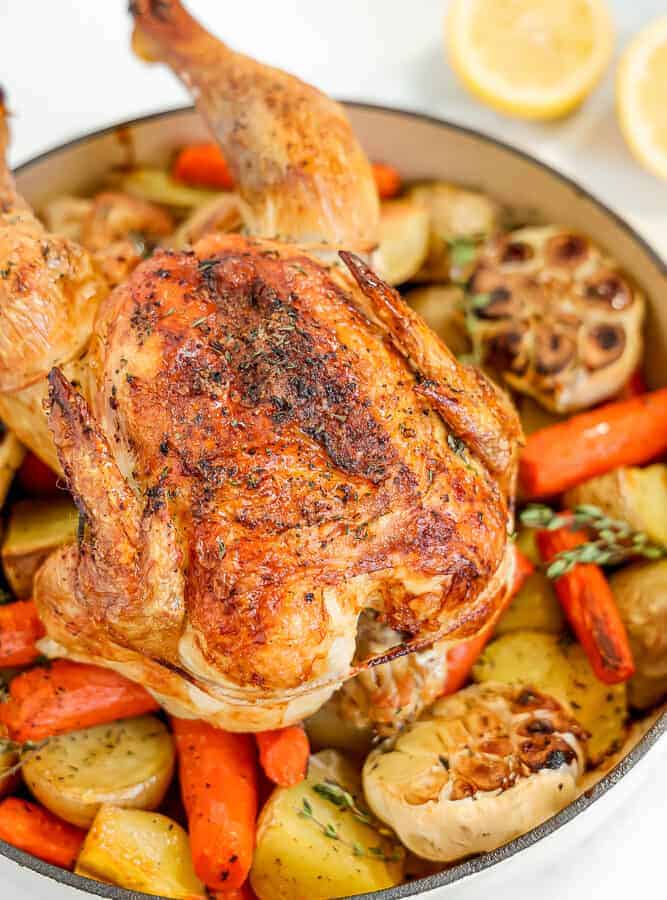 whole roasted chicken on bed of vegetables