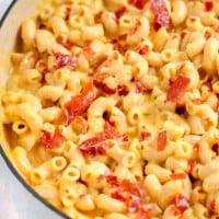 close up of creamy mac an cheese with prosciutto on top