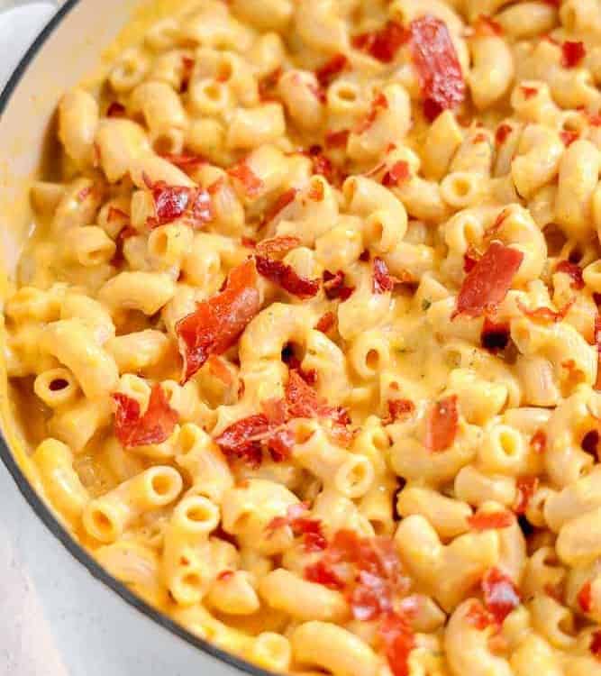 close up of creamy mac an cheese with prosciutto on top