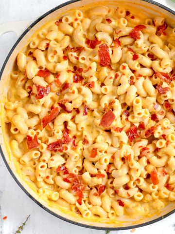 close up of macaroni and cheese with crispy prosciutto on top