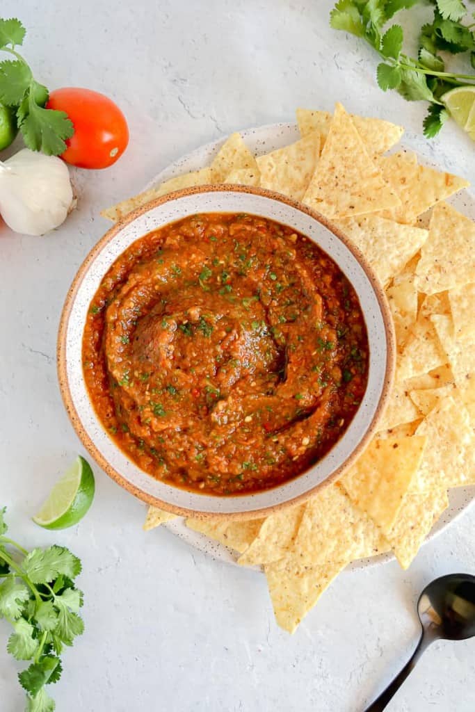 homemade salsa surrounded by chips and fresh vegetables