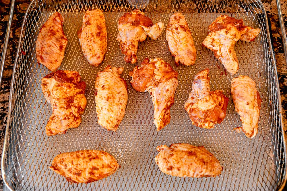 wings rubbed in spices in air fryer basket