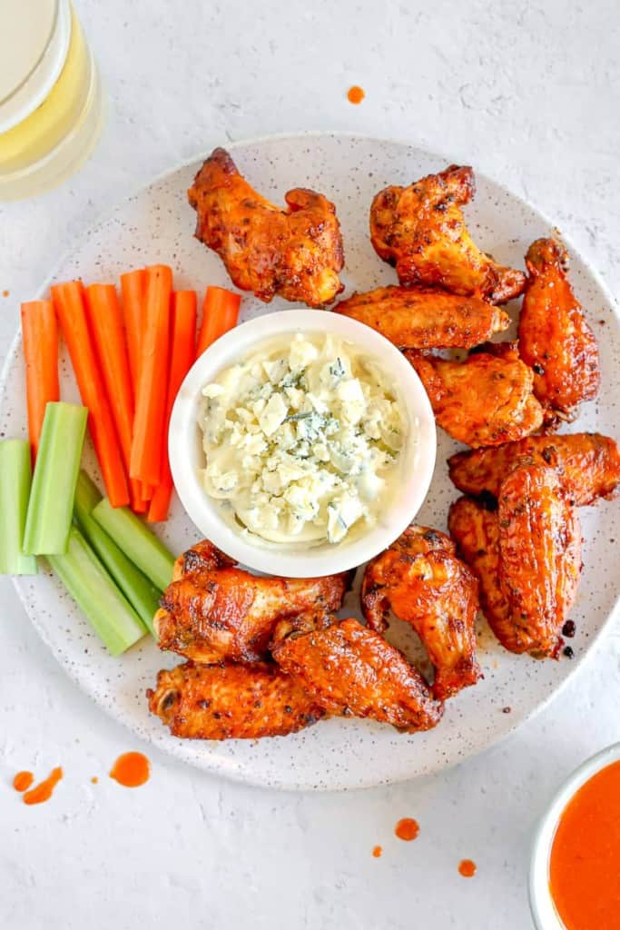 plate of chicken wings, celery, carrots, and blue cheese 