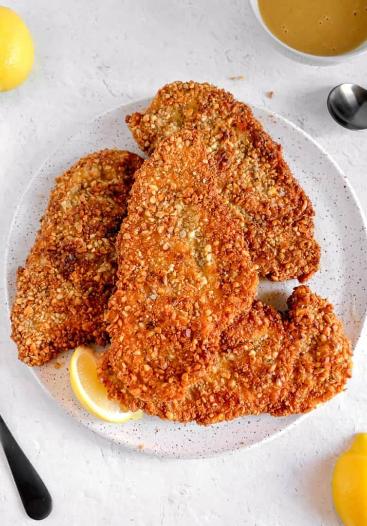 nut and seed encrusted chicken cutlets on a white plate