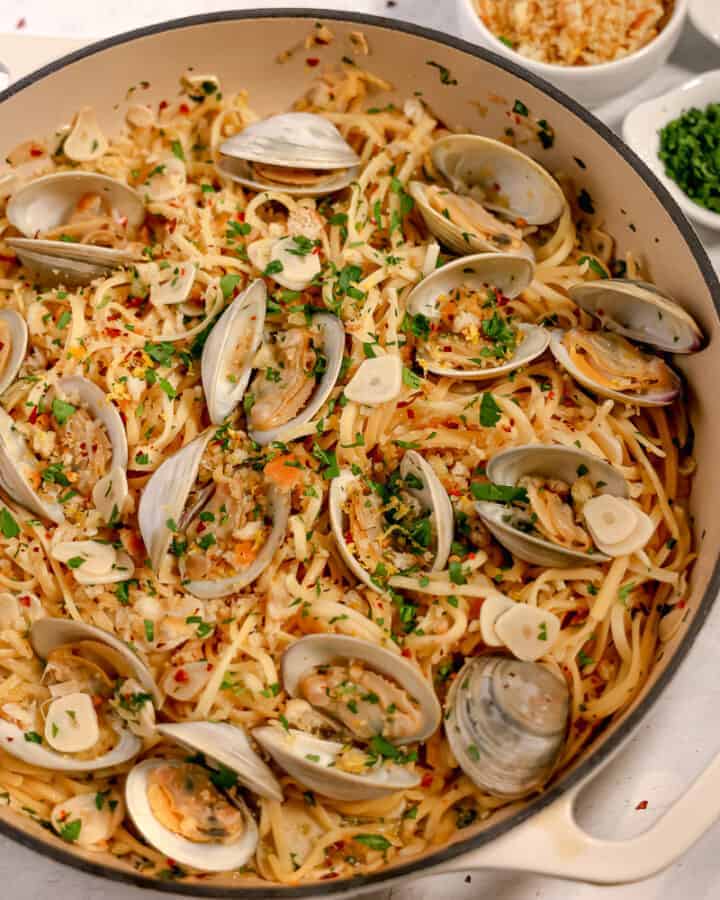 clams and linguine in a pot with fresh herbs and breadcrumbs