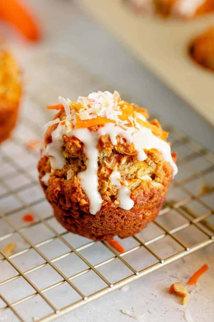 carrot cake muffin with glaze dripping off side on a gold stand