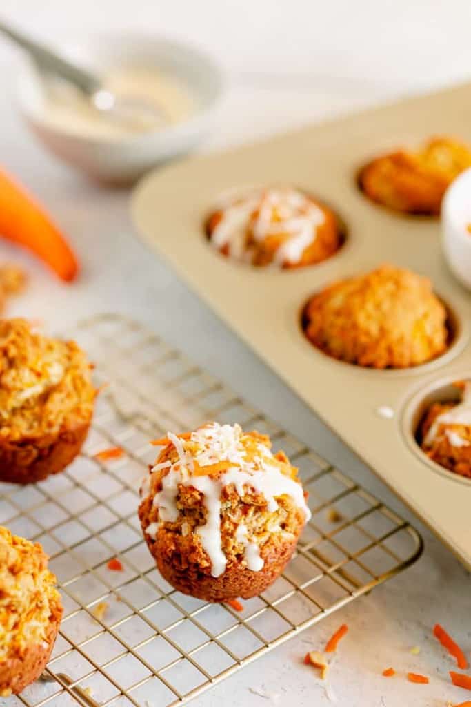 cream cheese glazed carrot cake muffins on a cooling rack