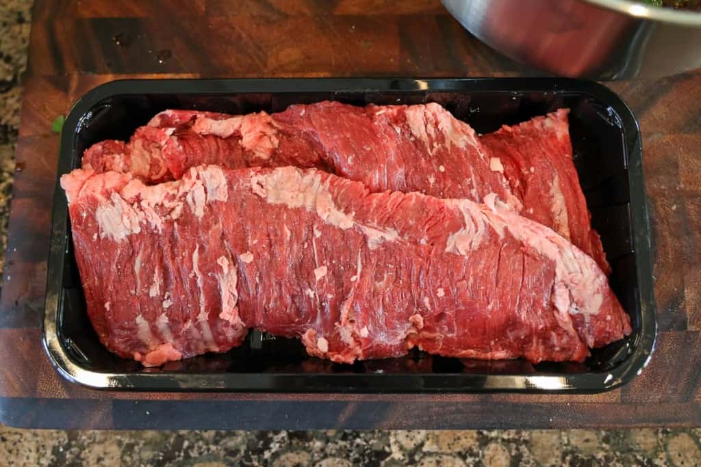 raw skirt steak on a black container 