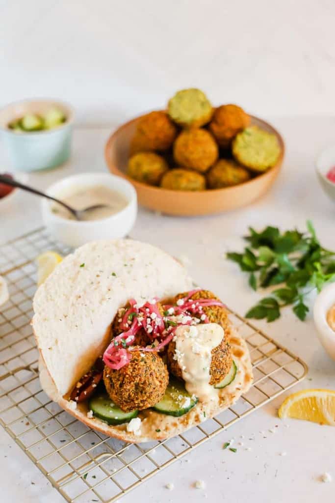 falafel on a pita with cucumber tahini and pickled red onions
