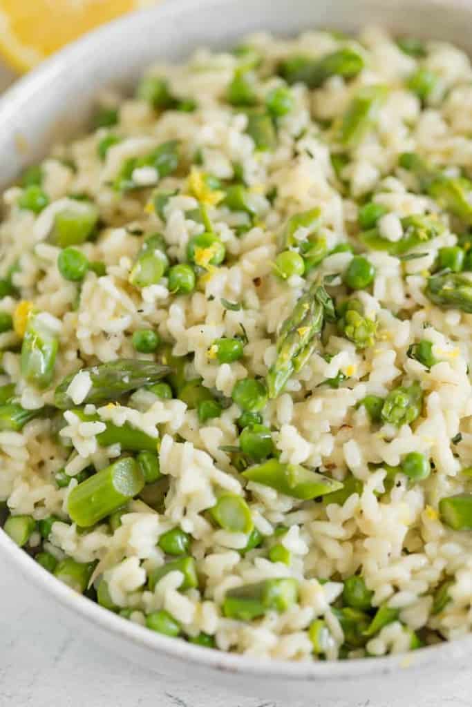 close up of peas and asparagus mixed in creamy risotto